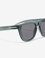 Lentes de sol Hawkers modelo One Raw con armazón de policarbonato transparente en tono gris oscuro y cristales oscuros.