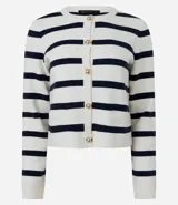 Cardigan de punto con diseño rayado horizontal en color blanco y rojo. Presenta escote redondo, manga larga, cierre frontal con botones dorados y bolsillos delanteros discretos. Posee una caída estructurada y acabado sofisticado.