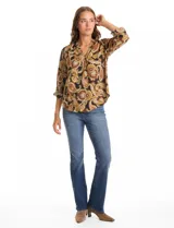 Blusa de gasa marca Floral & Ivy con estampado de arabescos en tonos tierra. Presenta cuello a la base con escote en V, mangas tres cuartos con sistema de ajuste mediante presilla y botón.