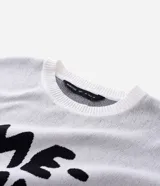 Suéter de corte boxy confeccionado en tejido jacquard de viscosa y poliéster. Presenta cuello redondo, mangas largas y un diseño estampado con lettering en color negro sobre fondo blanco.