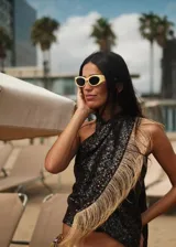 Top negro de lentejuelas con detalle de flecos de rafia en el lateral. Diseño halter con tiras para atar en el cuello.