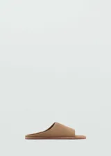 Sandalias planas de piel bovina en color tostado, con diseño destalonado, puntera abierta y una sola tira ancha en el empeine.