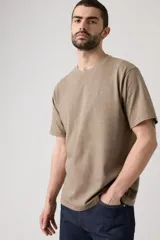 Remera de algodón con cuello redondo y mangas cortas, de corte relajado y color marrón con efecto desgastado. Presenta un pequeño logo bordado en el pecho.