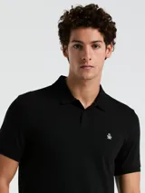 Polo negra de piqué de algodón orgánico, corte recto, cuello con solapa y logo bordado en el pecho.