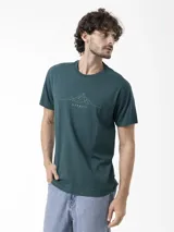 Remera Merrell de manga corta en color verde oscuro, cuello redondo y diseño estampado en el pecho con gráfico de montañas y logotipo de la marca.