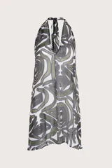 Vestido corto con escote halter y silueta de caída natural, confeccionado en tela ligera con estampado orgánico en tonos verdes y violetas sobre fondo blanco.