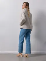 Campera beige capitoneada con capucha, cierre frontal y bolsillos laterales.