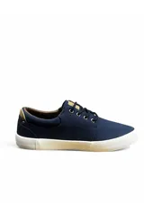 Calzado náutico azul marino con cordones oscuros, suela blanca de goma y detalle de logo bordado en el lateral. Cuenta con ojales metálicos y apliques en marrón claro.