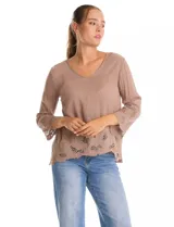 Blusa de rayón color marrón con escote en V y mangas tres cuartos acampanadas. Presenta detalles de bordado suizo y calados florales en los puños y en el ruedo asimétrico con terminación festoneada.