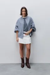Short pollera de tiro alto confeccionado en algodón, con diseño cruzado en el delantero que simula una falda, cierre lateral invisible y bolsillos traseros.