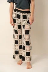 Pantalón de crochet con diseño a cuadros en blanco y negro, de corte recto y tiro alto.