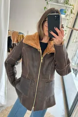 Campera reversible de cuero genuino napalán color negro, con cuello y detalles de corderito sintético, cierre frontal y bolsillos ribeteados.