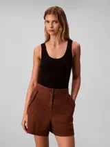 Short cargo de talle alto confeccionado en una mezcla de lino y algodón. Presenta cierre frontal con botón y cremallera, bolsillos laterales con solapa y botones decorativos, ofreciendo un estilo utilitario y relajado.