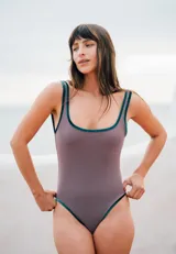 Traje de baño entero color visón con bordes de terciopelo verde inglés y detalle de óvalo en la espalda.