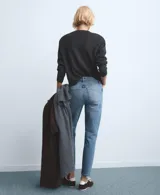 Pantalón de jean de corte recto y tiro medio, con diseño clásico de cinco bolsillos y cierre frontal con botón y cremallera. Presenta un acabado en tono azul medio con sutiles desgastes.