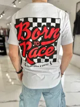 Remera oversize blanca de manga corta, con gran estampado en la espalda de estilo automovilístico con la leyenda "Born to Race" en rojo sobre un fondo de damero negro y blanco, acompañado por el texto "Racing Speed & Destroy".