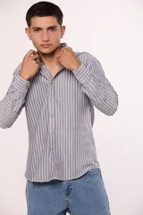 Camisa de manga larga con estampado de rayas verticales, cuello abotonado y cierre frontal con botones.