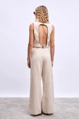 Chaleco color crudo con cuello en V y botones frontales.