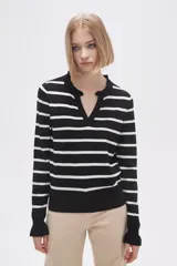 Sweater de punto a rayas horizontales negras y blancas, con cuello en V adornado con pequeños volados y mangas largas.