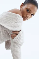 Top ajustado de punto acanalado suave color beige, con escote off-the-shoulder y mangas largas.