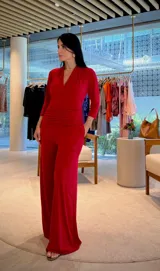 Mono largo color rojo, con escote en V, mangas 3/4 y detalle de faja fruncida en la cintura. Incluye bolsillos laterales.