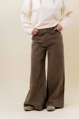 Pantalón de denim color marrón, de tiro medio-alto y calce wide leg con pierna amplia.