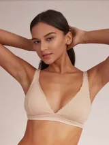 Soutien tipo halter de algodón color blanco, con diseño triangular y detalle de puntilla en los bordes.