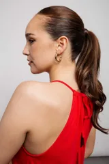 Vestido largo color crema, sin mangas, con cuello halter ajustable y falda con volantes.