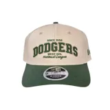 Gorra New Era modelo 9Forty con visera curva, cuerpo en color beige y visera en color verde. Presenta un diseño bordado en el frente con la inscripción 'Dodgers' en letras verdes con borde oscuro, junto a detalles adicionales en texto. Incluye el logo de la marca bordado en el lateral.