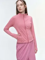 Campera deportiva de cuello alto con cierre frontal de doble cursor. Presenta un corte ajustado que realza la silueta, bolsillos laterales con cierre y mangas largas con puños con abertura para el pulgar.