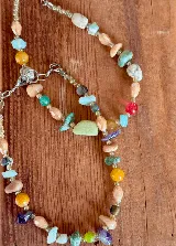 Gargantilla de piedras naturales multicolor en tonos tierra, verde, amarillo y rojo, con diseño de cuentas irregulares y perlas.