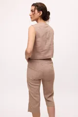 Pantalón capri color beige, de tiro alto y corte recto. Confeccionado en lino y algodón.