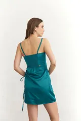 Vestido corto color borgoña, con breteles finos, escote recto y drapeado lateral con cordones ajustables.