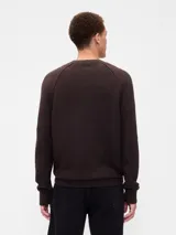 Buzo de punto para hombre, de color azul marino, con cuello redondo y mangas tipo raglán. Presenta puños y ruedo acanalados.