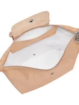 Mochila de diseño minimalista en color beige, con cierre superior de cremallera y solapa frontal con botón a presión. Presenta un asa superior y correas ajustables, con el logo de la marca grabado en la solapa.