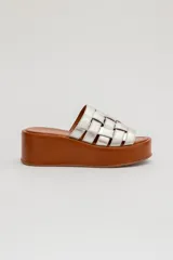 Sandalias de cuero Agnès Lenoble con plataforma plana y suela de madera, capellada con tiras doradas entrelazadas.