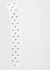 Camiseta blanca de algodón con cuello redondo y mangas cortas con tachas decorativas en los hombros.