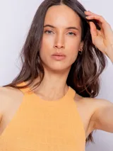 Top blanco de tejido de punto con textura a cuadros, cuello redondo y sin mangas.