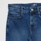 Jean slim de hombre color azul, con cierre de botón y cremallera, y bolsillos delanteros y traseros.