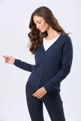 Saco tejido fino de hilo de algodón color beige, con cuello en V, cierre frontal con botones y puños acanalados.