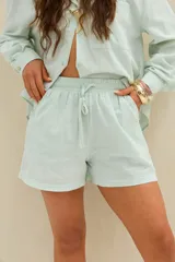 Short celeste a rayas finas blancas, con cintura elástica y cordón ajustable.