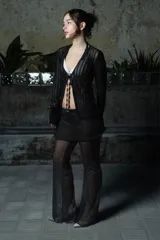 Pantalón de pierna ancha con sobrepollera integrada de tul semitransparente, confeccionado en tela negra liviana. Presenta un diseño de doble capa que aporta movimiento y textura a la prenda.