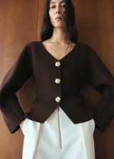 Chaqueta de punto color marrón oscuro, con escote en V, mangas largas abullonadas y cierre frontal con grandes botones dorados grabados.