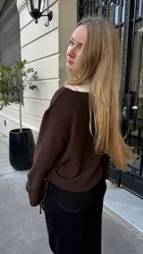 Buzo de punto color chocolate con textura acanalada, cuello redondo y diseño ajustable en los laterales mediante tiras que permiten regular el largo.