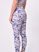 Calza larga de lycra estampada con diseño geométrico abstracto en tonos borgoña, blanco y marrón.