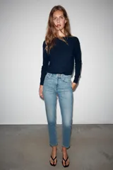 Jeans mom fit de tiro alto color negro con efecto lavado, diseño de cinco bolsillos y corte tobillero.