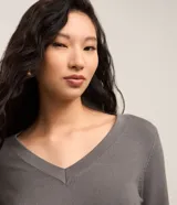 Suéter de punto color amarillo, con escote en V y mangas largas. Presenta un diseño básico y versátil, confeccionado en una mezcla de viscosa, poliamida y elastano.