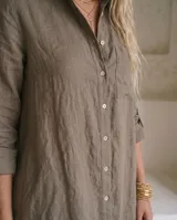 Vestido camisero de lino color marrón, de corte recto y largo midi, con mangas largas abotonadas, cuello camisero y cierre frontal con botones de nácar.