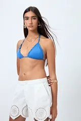 Top de bikini negro con tirantes finos y volados en el borde.