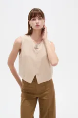 Musculosa cropped de viscosa color rosado, con cuello a la base, pequeña abertura frontal y detalle de hebilla metálica decorativa.
